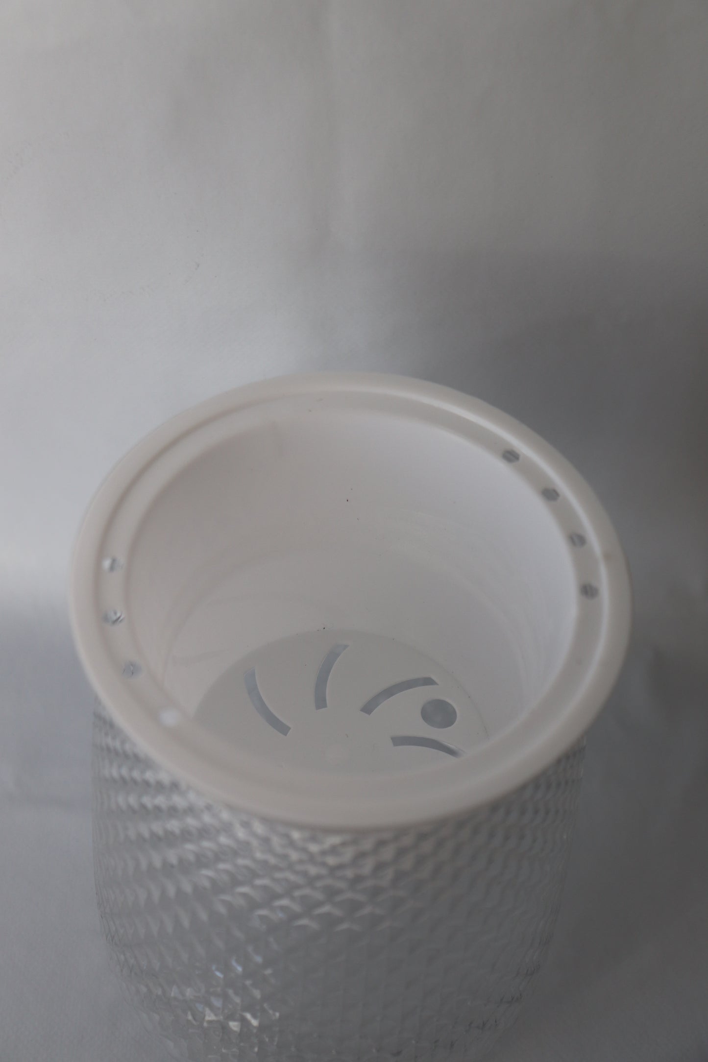 Clear plastic self-watering planter with water reservoir for easy care