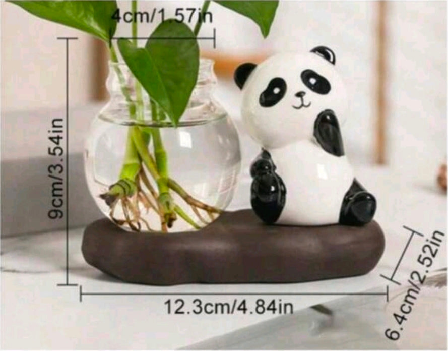 Panda figurine with a glass vase containing green leaves on a white surface, with measurements indicated.